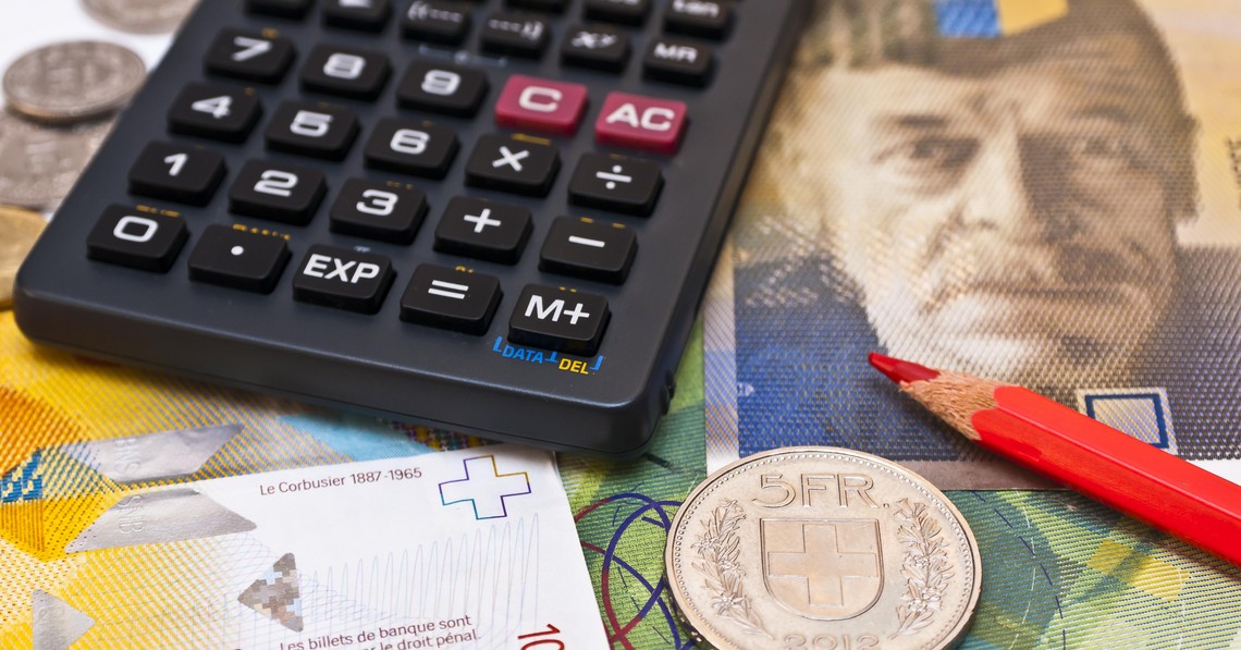 Symbolbild Produzenten- und Importpreisindex, Taschenrechner, roter Bundstift und fünf Franken Münze liegen auf Schweizer Banknoten