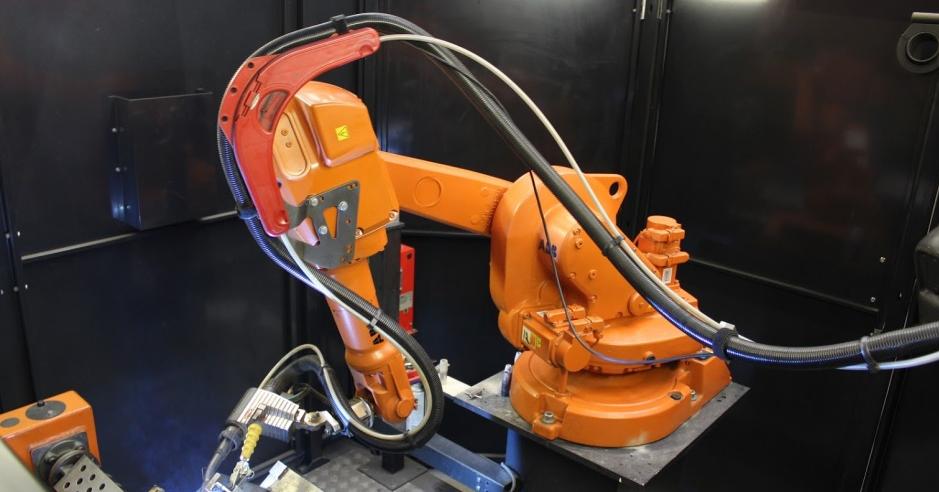 Oranger Schweissroboter bei Aartech der arbeitet