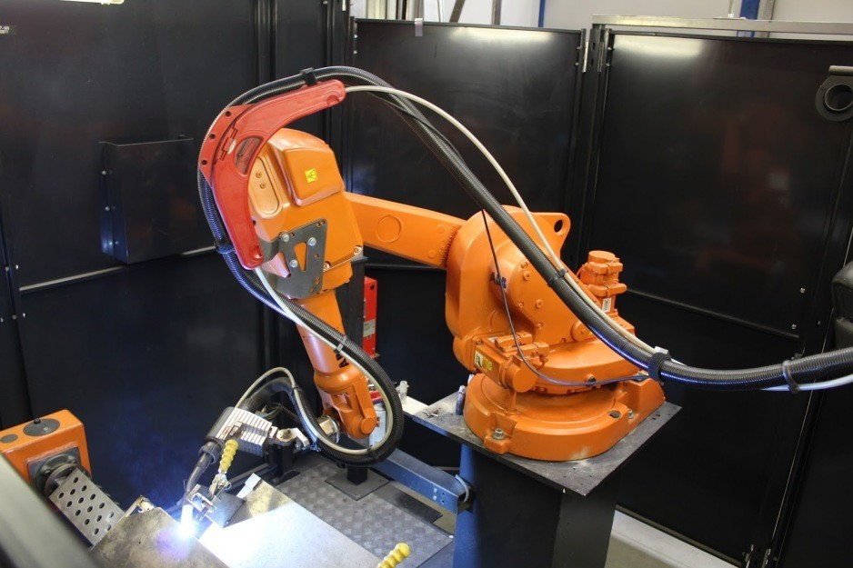Oranger Schweissroboter bei Aartech der arbeitet