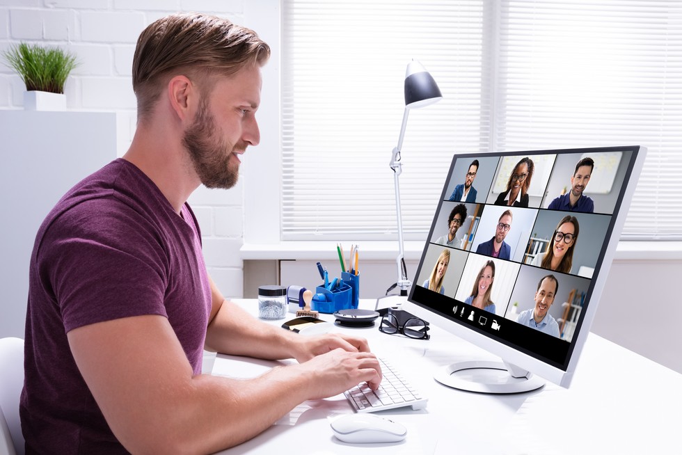 Lehrgang Sezialistin Spezialist öffentliche Beschaffung Klasse Bild mit einem Mann, welcher in seinem Computerbildschirm schaut und ein Online-Meeting führt