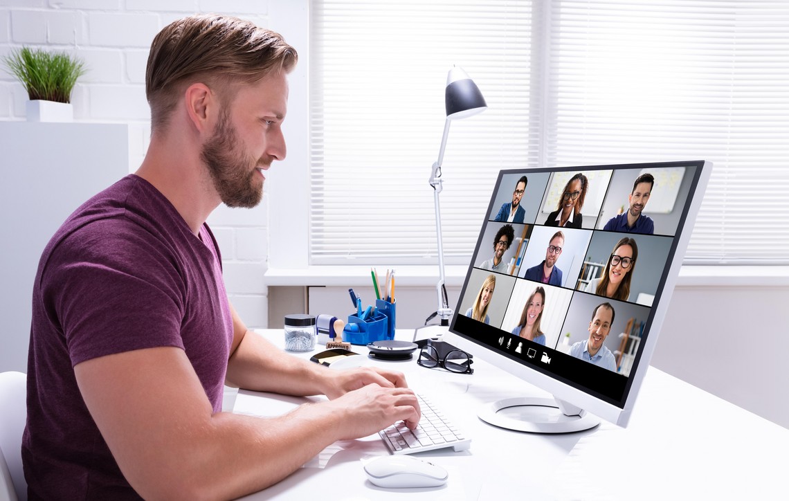 Bild mit einem Mann, welcher in seinem Computerbildschirm schaut und ein Online-Meeting führt