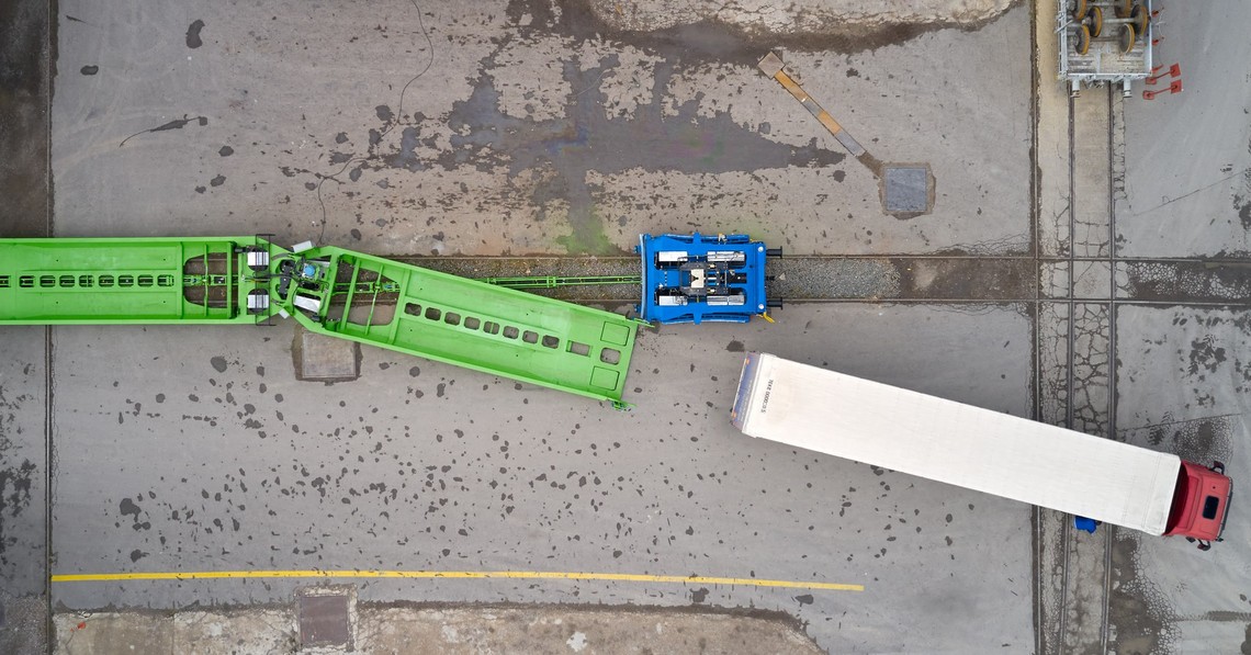 Lastwagen und horizontale Verladetechnik auf Schiene auf Vogelperspektive