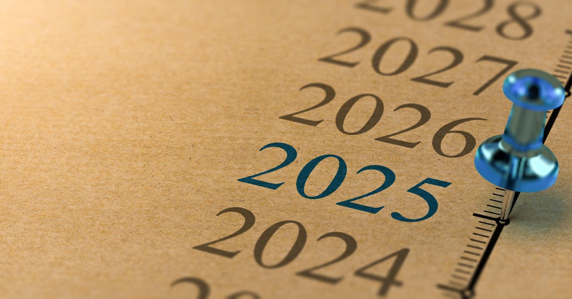 Goldener Kalender mit Jahreszahlen. Mit einer blauen Stecknadel bei 2025.