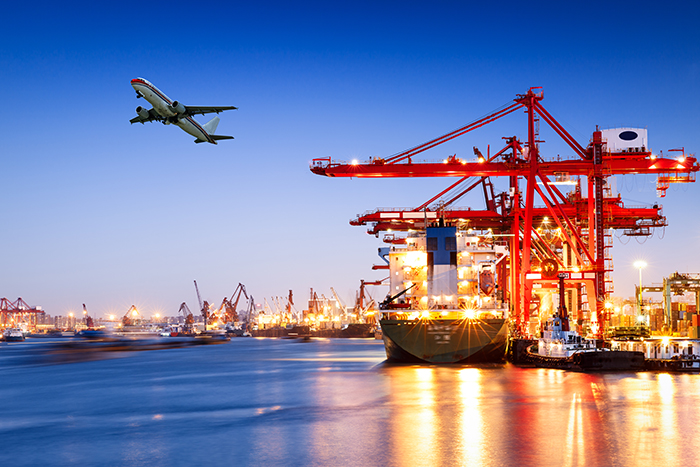 Hafen mit grossen roten Kräne und ein startendes Flugzeug